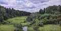 Photographic art picture of countryside typical Russian landscape with forest and river under cloudy dramatic blue sky