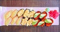 Photographic art picture of various types of sushi pieces with caviar, molusks on white plate with green wasabi and red colored Royalty Free Stock Photo