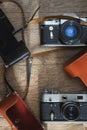 Photographic equipment - old retro film photo cameras and leather cases on wooden background Royalty Free Stock Photo