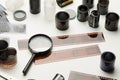 Photographic films, scissors and magnifying glass on white background