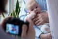 Photographing baby girl or shooting video on digital camera, funny family photo session