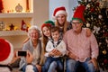 Photographing smiling family with smartphone for Christmas