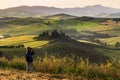 Photographing Tuscany landscape with traditional farm house, hills and meadow at sunrise. Val d`orcia, Italy.