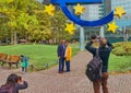 Photographing tourists in front of the euro sculpture in front of the old former building of the European Central Bank ECB