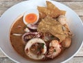 a photography of a bowl of food with a tortilla and an egg, plate of food with a variety of foods in it on a wooden table