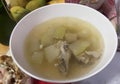 a photography of a bowl of soup with meat and vegetables, consommeganized soup in a bowl with a side of fruit Royalty Free Stock Photo