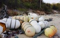 a photography of a bunch of buoys sitting on top of a sandy beach, ping - pong ball floats on the beach with rope and rope