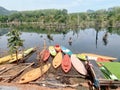 a photography of a bunch of kayaks are sitting on the shore, canoes are lined up on the shore of a lake Royalty Free Stock Photo