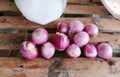 a photography of a bunch of onions on a wooden table, mortar and a pile of onions on a wooden table Royalty Free Stock Photo