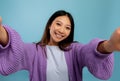 Photography concept. Portrait of asian woman taking selfie picture, point of view pov shot of smiling lady