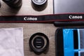 Photography flat lay on a grey wood table. Canon strap in focus