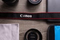 Photography flat lay on a grey wood table. Canon strap in focus