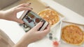 Photography of food. Hands take pictures of delicious pizza and rolls with a smartphone
