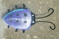 Ladybug painted purpel on a sidewalk Royalty Free Stock Photo