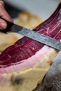 Iberian ham cut into small slices with a knife.