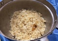 a photography of a pan filled with rice and a spoon, frying pan filled with cooked rice and a wooden spoon