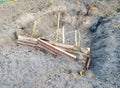 a photography of a pile of pipes in a dirt pit, there is a pile of pipes in the dirt with a blue sky in the background