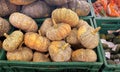 a photography of a pile of pumpkins in a green crate, spaghetti squash and pumpkins are stacked in crates at a market