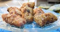 a photography of a plate of food with meat on a stick, there are several skewered meats on a blue plate