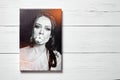 Photography printed on canvas. Portrait of a beautiful young woman. Photo hanging on wooden wall Royalty Free Stock Photo