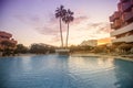 Photography of a residential area during the sunset with palms and pool