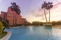 Photography of a residential area during the sunset with palms and pool