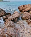 a photography of a rocky beach with a few rocks in the water, sea - coast scene with rocks and waves crashing on the shore Royalty Free Stock Photo