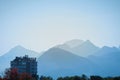 Silhouette of the misty blue mountains in the colorful light of sun with nature and city in foreground - autumn Royalty Free Stock Photo