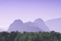 Silhouette of the misty purple mountains in the colorful light of sun with nature and city in foreground - look like boobs Royalty Free Stock Photo