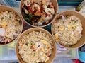 a photography of three bowls of food on a table, corn, shrimp, and rice in bowls on a tray