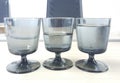 a photography of three glasses of water sitting on a table, three glasses of water sit on a table next to a laptop Royalty Free Stock Photo