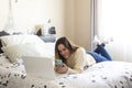 Photography of a woman teleworking in her bed and chatting with coworkers. Remote working woman