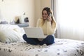 Photography of a woman teleworking in her bed from home talking on the phone. Coronavirus quarantine. Remote working woman