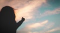 Young woman pointing at the moon in the sky - colorful sky during sunset - abstract of exploration and hope humankind