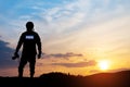 Photojournalist silhouette documenting war or conflict. Photojournalist at sunset.