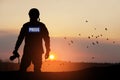 Photojournalist silhouette documenting war or conflict. Photojournalist at sunset.