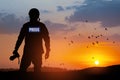 Photojournalist silhouette documenting war or conflict. Photojournalist at sunset.