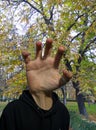 Photomontage of a hand in the position of the head in the middle of an autumnal path in a park in Madrid