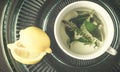 Photoof green tea with mint and lemon balm flowers in a white cu