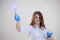 Photopolymer lamp a woman doctor like a Fairy waves a polymer lamp like a magic wand in a white suit on a white