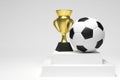 Soccer ball and a gold cup in a white studio