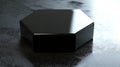 A photorealistic image of a glossy black hexagonal box with sharp edges and clean design