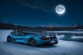 A photorealistic McLaren 720S parked under a moonlit winter sky starry frozen lake generative by Ai