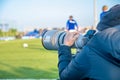 Photoreporter with telephoto lens on a football match Royalty Free Stock Photo