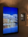 Photos of beautiful pastel buildings along the river Inn displayed on the big screen of Tourist Information Innsbruck office.