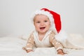 Photos of smiling young baby in a Santa Claus hat