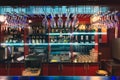 Photos of a stylish bar with colorful bright interior in the restaurant. Alcohol bars, bar counter, bartender`s workplace. Empty Royalty Free Stock Photo