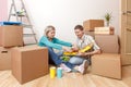 Photos of women and men eating pizza among cardboard boxes Royalty Free Stock Photo