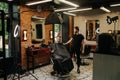 Photosession in a barber shop. Client in a chair, hairdresser next to him