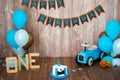 Photoshoot crush smashcake for a little boy gentleman. Decorated photozone with a wooden retro car and helium balloons. Happy Royalty Free Stock Photo